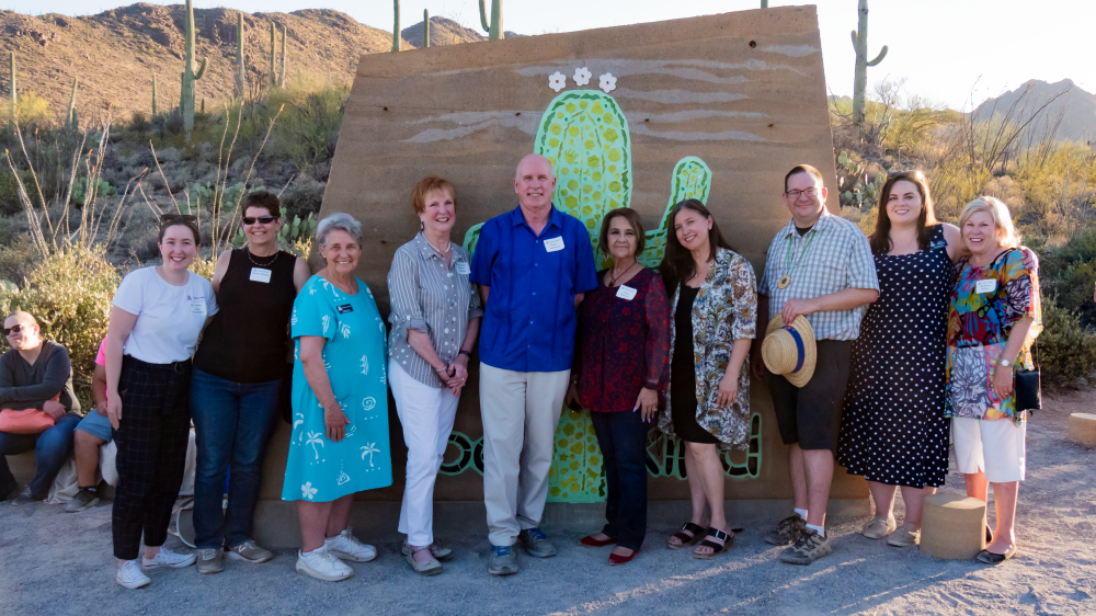 Dean Johnson and College of Education Staff in front of the Kindness Wall at Camp Cooper