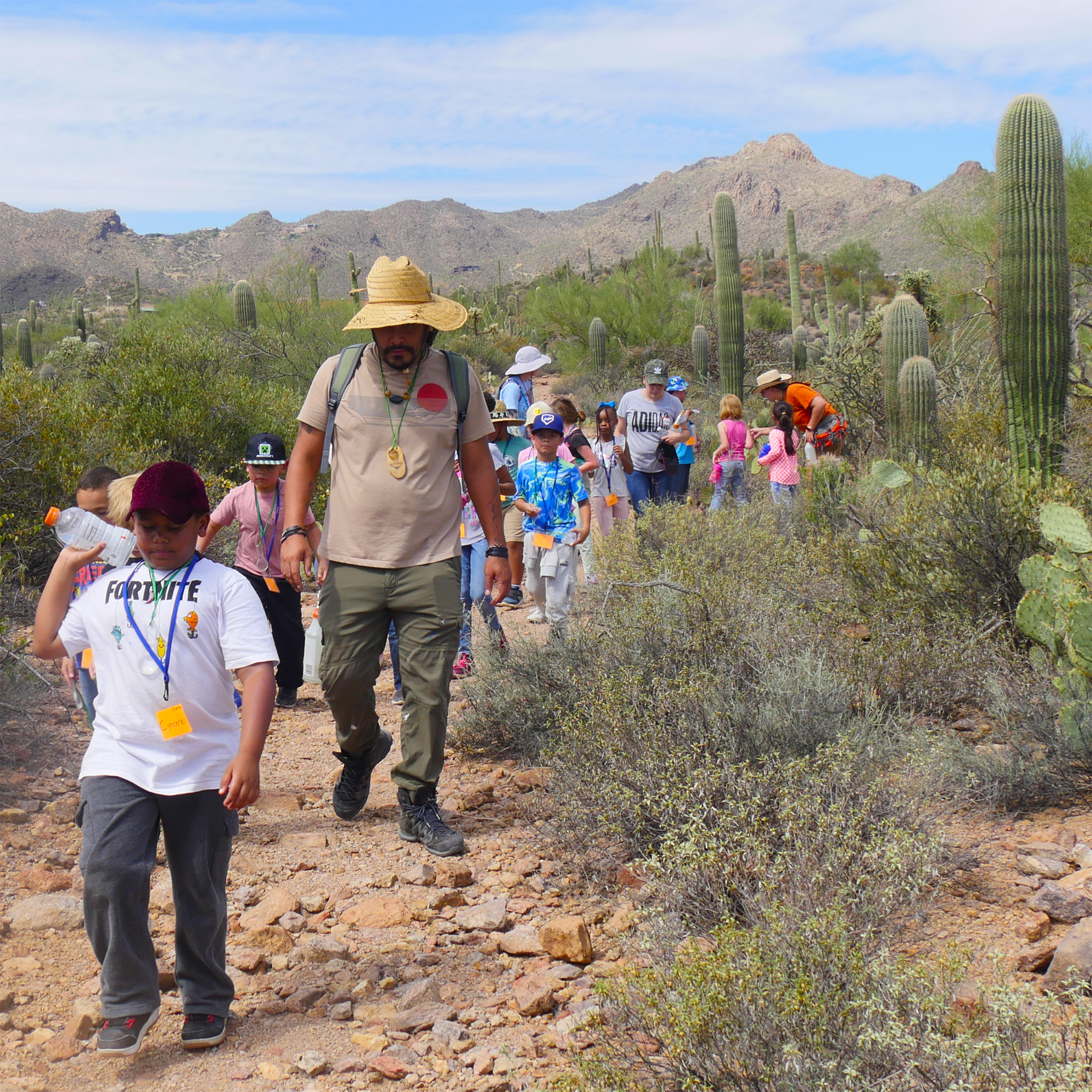 Educator Isaac leads second-graders on a discovery hike at Camp Cooper.