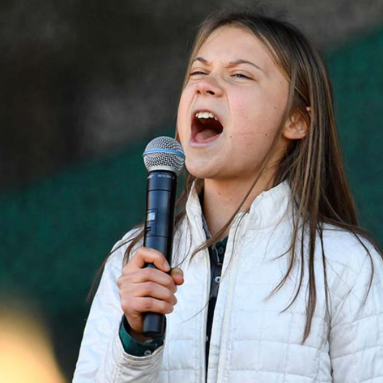 greta thunberg holding a microphone, singing